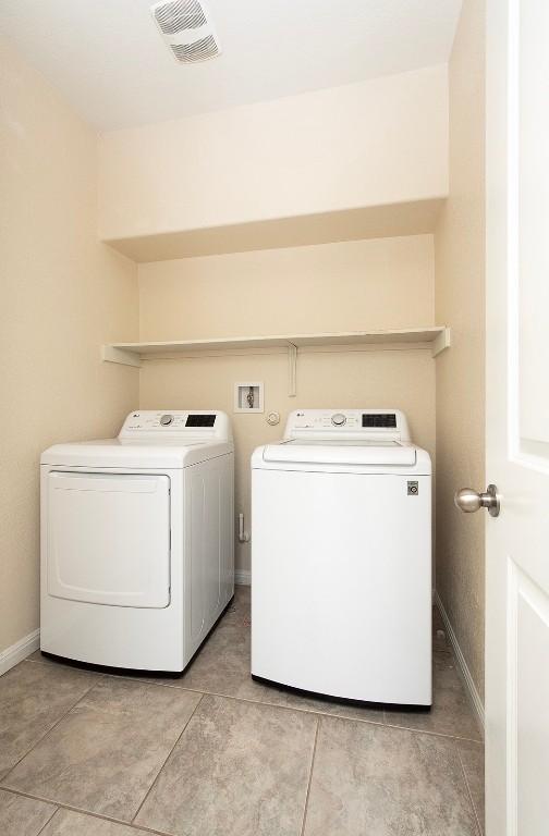 112 Moulins Ln, Georgetown, TX 78626 - washroom featuring washer and dryer, baseboards, and light tile patterned flooring