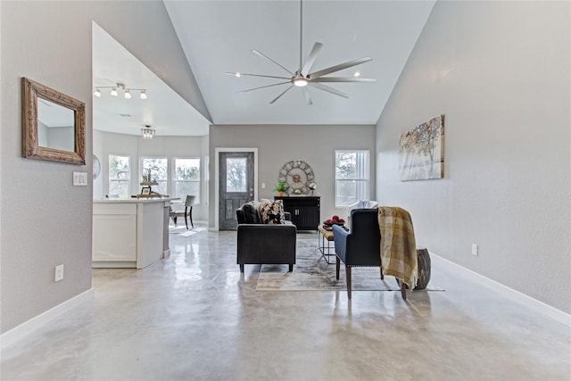 living room featuring a ceiling fan, baseboards, high vaulted ceiling, and finished concrete floors