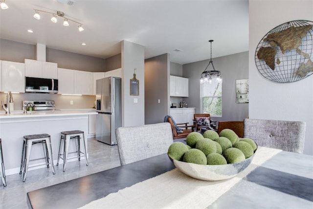 dining space featuring a chandelier and finished concrete flooring