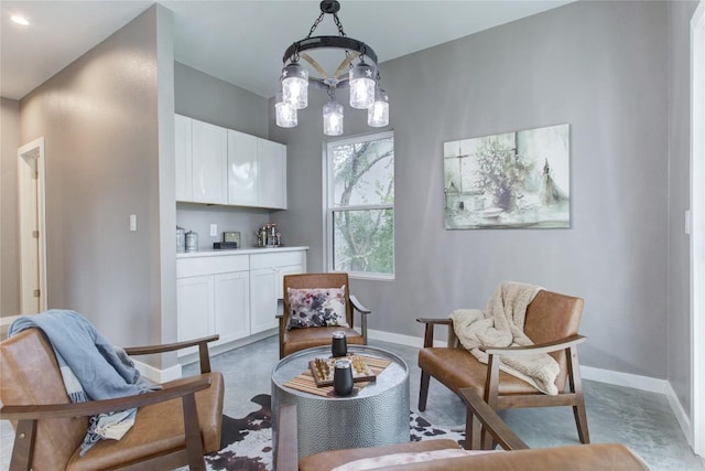 sitting room with baseboards and a chandelier