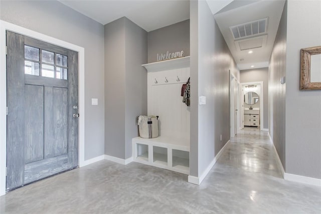 mudroom featuring concrete flooring and baseboards