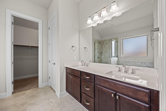 316 Barrel Bnd, Georgetown, TX 78628 - full bathroom featuring a stall shower, double vanity, a walk in closet, and tile patterned flooring