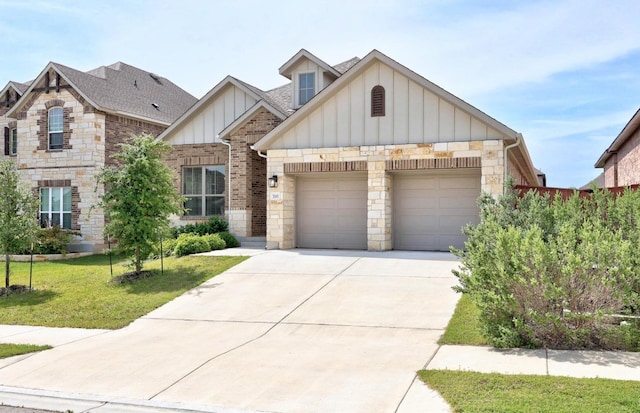 316 Barrel Bnd, Georgetown, TX 78628 - view of front facade with board and batten siding, an attached garage, driveway, a front lawn, and stone siding