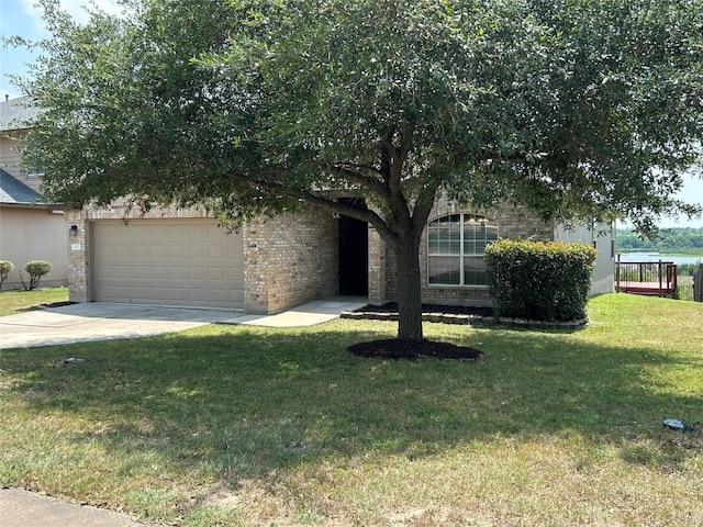 670 Covent Dr, Kyle, TX 78640 - view of property hidden behind natural elements with an attached garage, driveway, brick siding, and a front yard