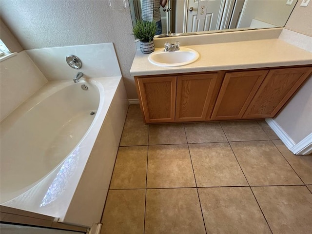 670 Covent Dr, Kyle, TX 78640 - bathroom featuring a garden tub, vanity, and tile patterned floors