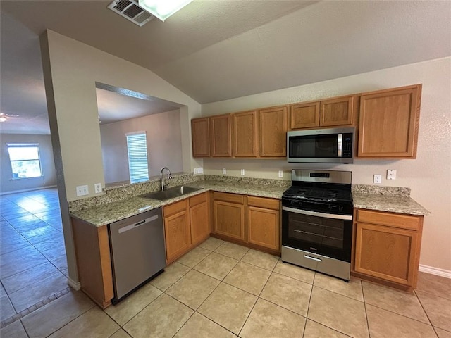 670 Covent Dr, Kyle, TX 78640 - kitchen featuring stainless steel appliances, a sink, plenty of natural light, lofted ceiling, and light tile patterned floors