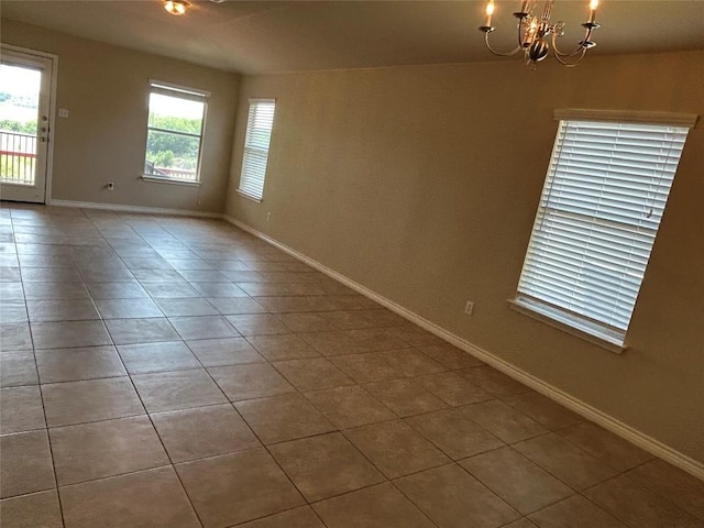 670 Covent Dr, Kyle, TX 78640 - spare room featuring a chandelier, tile patterned floors, and baseboards