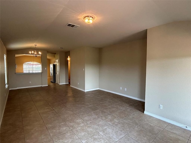 670 Covent Dr, Kyle, TX 78640 - empty room with a chandelier, vaulted ceiling, tile patterned floors, and baseboards