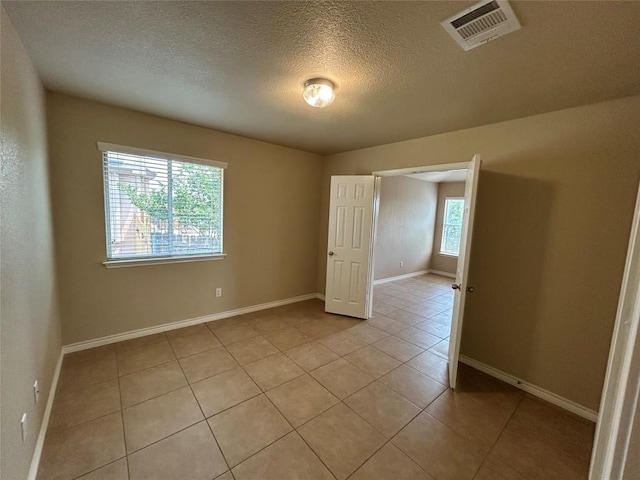 670 Covent Dr, Kyle, TX 78640 - spare room featuring light tile patterned floors, a textured ceiling, and baseboards