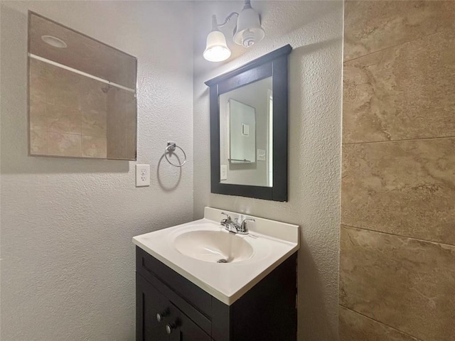 bathroom with vanity and a textured wall