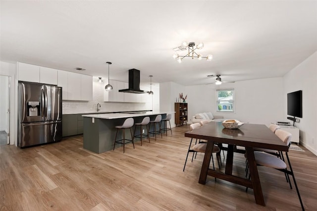 6309 Middleham Pl, Austin, TX 78745 - dining area featuring light wood-type flooring, a chandelier, and a ceiling fan