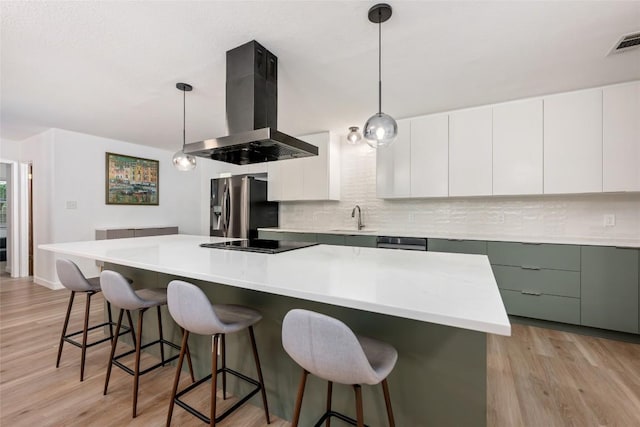 6309 Middleham Pl, Austin, TX 78745 - kitchen with wall chimney exhaust hood, stainless steel refrigerator with ice dispenser, backsplash, black electric stovetop, and light wood-type flooring