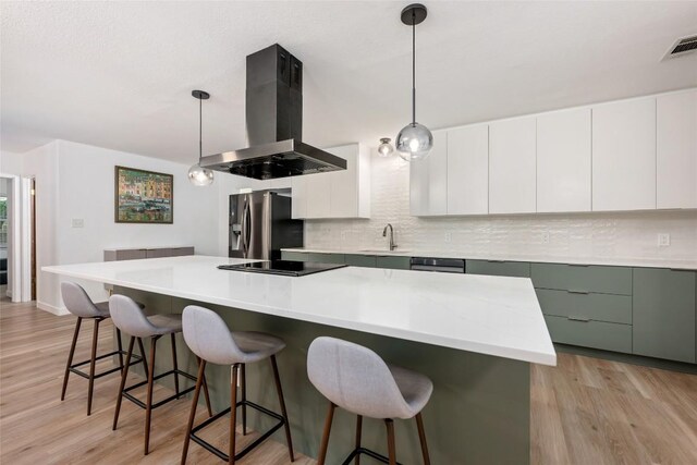6309 Middleham Pl, Austin, TX 78745 - kitchen featuring island range hood, stainless steel fridge with ice dispenser, tasteful backsplash, black electric cooktop, and a breakfast bar area
