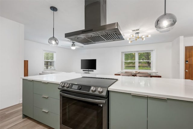 6309 Middleham Pl, Austin, TX 78745 - kitchen with stainless steel range with electric stovetop, wall chimney range hood, green cabinetry, open floor plan, and light countertops