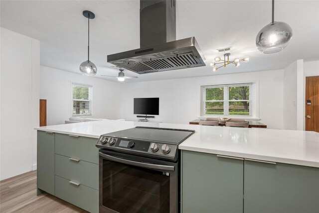 6309 Middleham Pl, Austin, TX 78745 - kitchen with wall chimney range hood, stainless steel range with electric stovetop, green cabinets, open floor plan, and light countertops