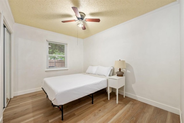 6309 Middleham Pl, Austin, TX 78745 - bedroom featuring ornamental molding, light wood-style floors, a textured ceiling, a closet, and ceiling fan