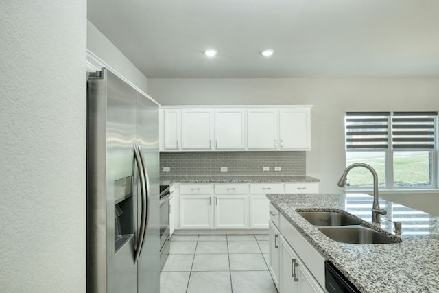 3209 Ortman Dr, Pflugerville, TX 78660 - kitchen with stainless steel appliances, a sink, backsplash, light tile patterned floors, and white cabinets