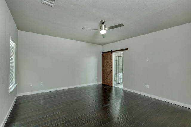 3209 Ortman Dr, Pflugerville, TX 78660 - empty room with a barn door, ceiling fan, wood finished floors, baseboards, and a textured ceiling