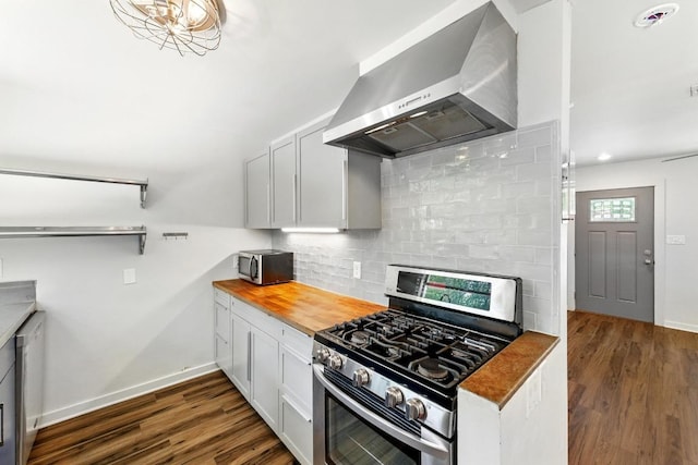 6209 Peggy St, Austin, TX 78723 - kitchen featuring wall chimney exhaust hood, appliances with stainless steel finishes, wood counters, tasteful backsplash, and dark wood-style flooring