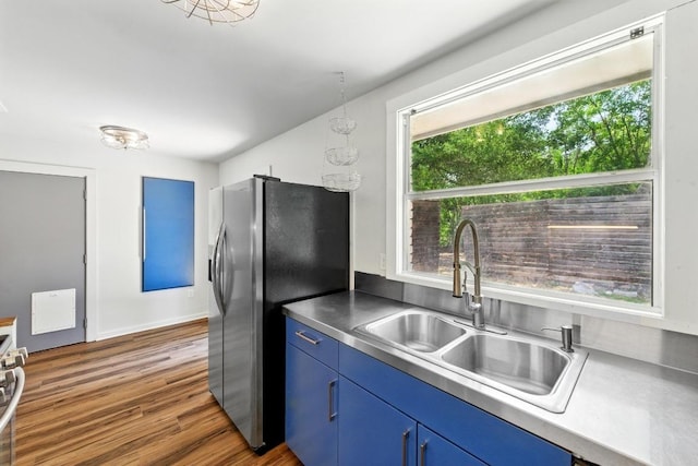 6209 Peggy St, Austin, TX 78723 - kitchen featuring stainless steel counters, stainless steel fridge with ice dispenser, blue cabinetry, dark wood-style floors, and range