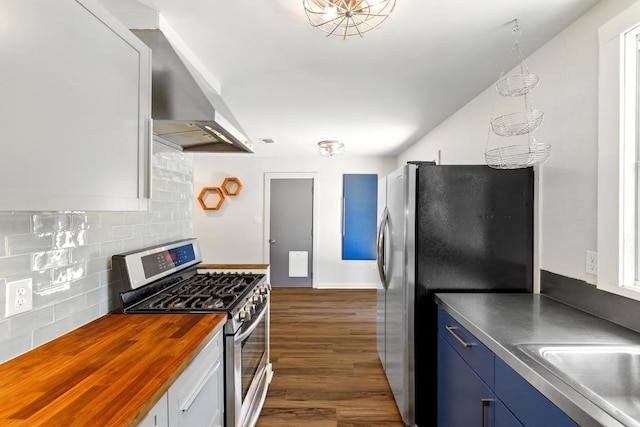 6209 Peggy St, Austin, TX 78723 - kitchen featuring stainless steel appliances, butcher block countertops, wall chimney range hood, backsplash, and dark wood finished floors