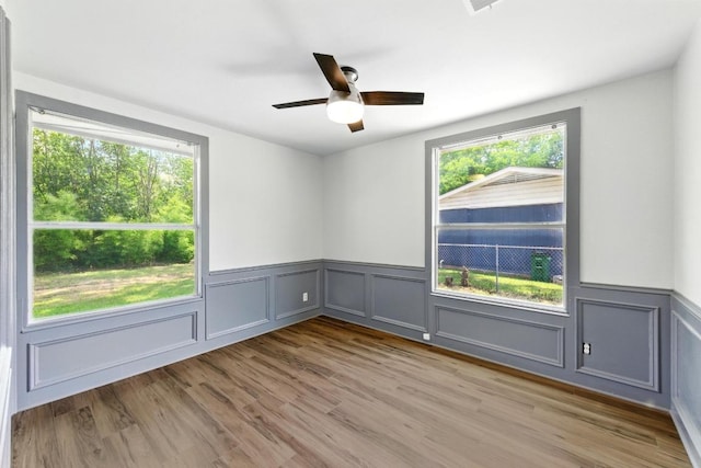 6209 Peggy St, Austin, TX 78723 - spare room featuring a wainscoted wall, ceiling fan, wood finished floors, and a decorative wall