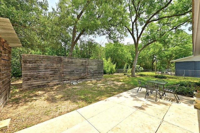 6209 Peggy St, Austin, TX 78723 - fenced backyard with a patio area, outdoor dining space, and view of scattered trees