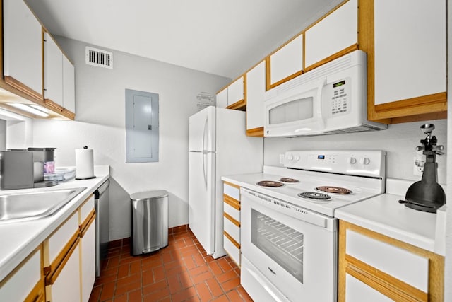 517 SW Pkwy Unit 104, College Station, TX 77840 - kitchen with white appliances, brick floors, light countertops, and electric panel