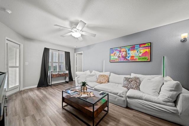 517 SW Pkwy Unit 104, College Station, TX 77840 - living area with wood finished floors, a ceiling fan, baseboards, and a textured ceiling