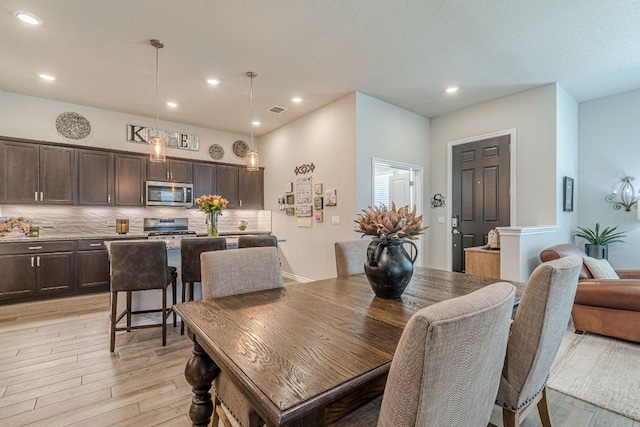 dining room with light wood-style flooring and recessed lighting