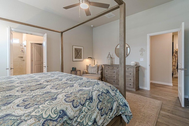 bedroom featuring wood finished floors, vaulted ceiling, baseboards, and a ceiling fan