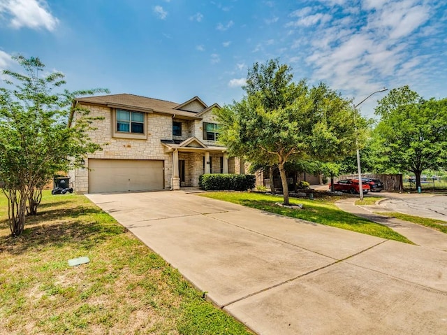 319 Sandstone Trl, Buda, TX 78610 - view of front of property featuring stone siding, an attached garage, concrete driveway, and a front yard