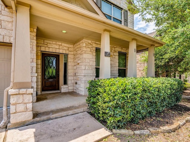 entrance to property with covered porch and stone siding