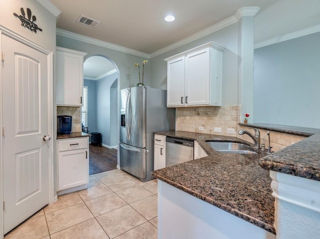 319 Sandstone Trl, Buda, TX 78610 - kitchen with appliances with stainless steel finishes, white cabinetry, dark stone countertops, ornamental molding, and backsplash