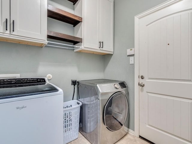 washroom with cabinet space and washing machine and clothes dryer
