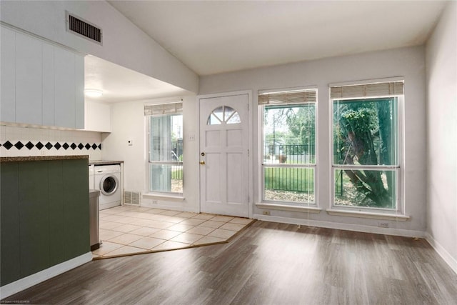 5601 Woodrow Ave Unit 109, Austin, TX 78756 - entryway featuring washer / clothes dryer, wood finished floors, and healthy amount of natural light