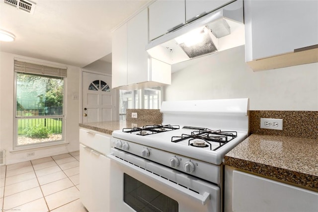 5601 Woodrow Ave Unit 109, Austin, TX 78756 - kitchen featuring white gas range, white cabinetry, under cabinet range hood, and light tile patterned flooring