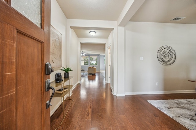 entryway with dark wood-type flooring and baseboards