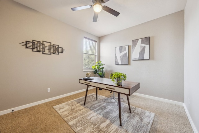 carpeted office space with ceiling fan and baseboards
