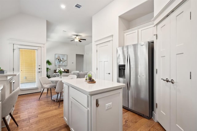 11009 Avery Station Loop Unit 32, Austin, TX 78717 - kitchen with stainless steel fridge, a ceiling fan, white cabinets, a kitchen island, and light countertops
