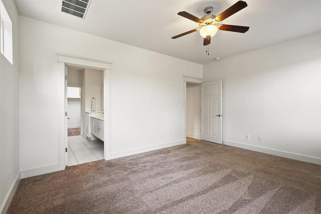 11009 Avery Station Loop Unit 32, Austin, TX 78717 - unfurnished bedroom with light colored carpet, baseboards, ensuite bathroom, and a ceiling fan