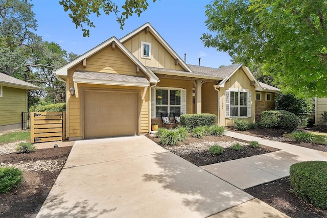 11009 Avery Station Loop Unit 32, Austin, TX 78717 - view of front of house featuring board and batten siding, an attached garage, a porch, driveway, and fence