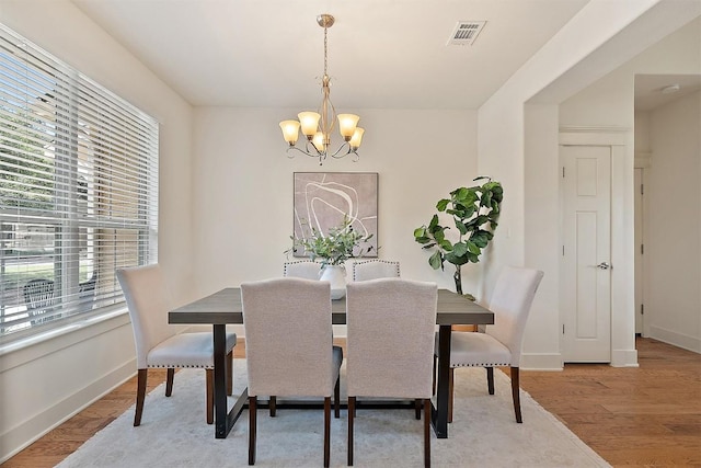11009 Avery Station Loop Unit 32, Austin, TX 78717 - dining area with a chandelier, baseboards, and light wood-style floors