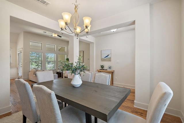 11009 Avery Station Loop Unit 32, Austin, TX 78717 - dining room featuring baseboards, wood finished floors, a chandelier, and a ceiling fan
