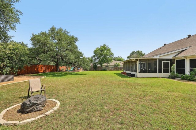 602 Leisurewoods Dr, Buda, TX 78610 - view of yard featuring a sunroom, a playground, and a fire pit