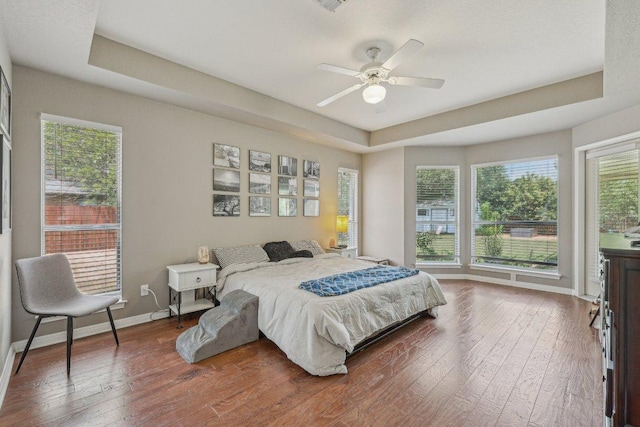 602 Leisurewoods Dr, Buda, TX 78610 - bedroom with a raised ceiling, wood-type flooring, baseboards, and a ceiling fan