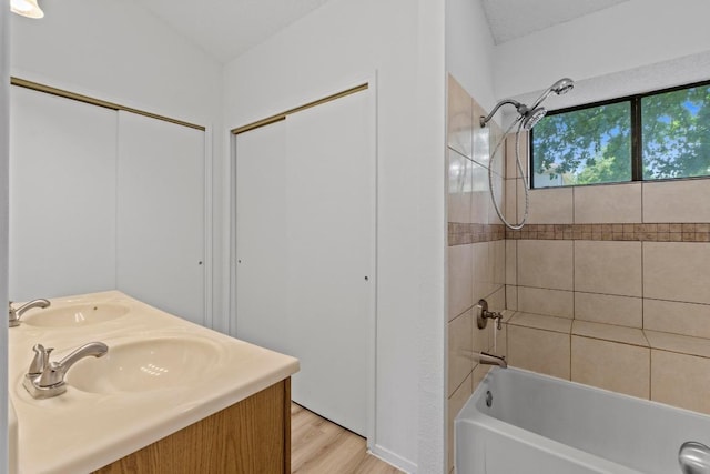 12309 Little Fatima Ln, Austin, TX 78753 - bathroom featuring bathtub / shower combination, wood finished floors, and double vanity