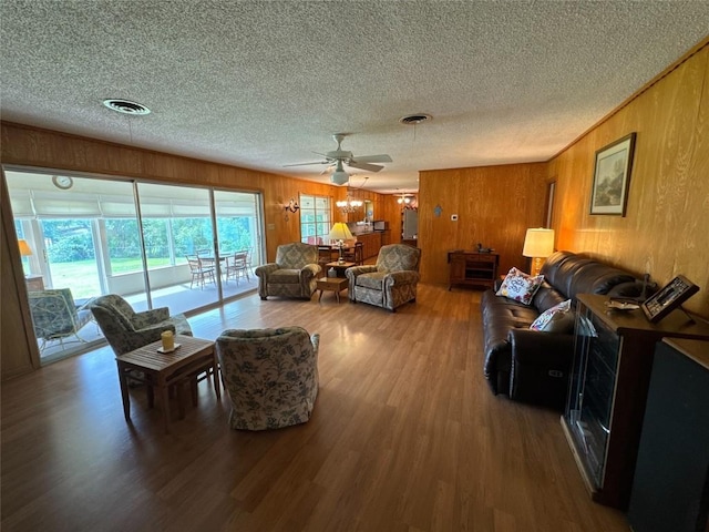 304 E Pheasant Rd, Highland Haven, TX 78654 - living area featuring a textured ceiling, wood finished floors, a ceiling fan, and wood walls