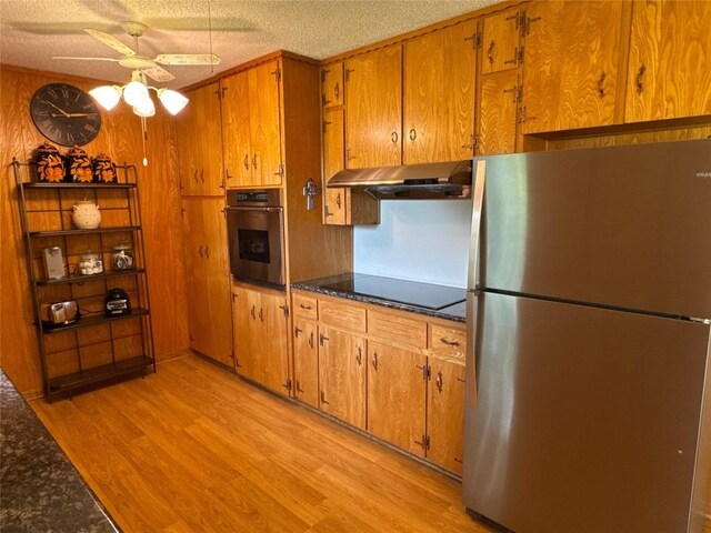 304 E Pheasant Rd, Highland Haven, TX 78654 - kitchen featuring stainless steel appliances, under cabinet range hood, light wood-style floors, ceiling fan, and brown cabinetry