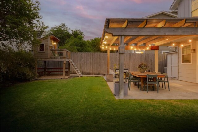 5607 Roosevelt Ave, Austin, TX 78756 - yard at dusk with a pergola, a fenced backyard, a patio area, and outdoor dining area